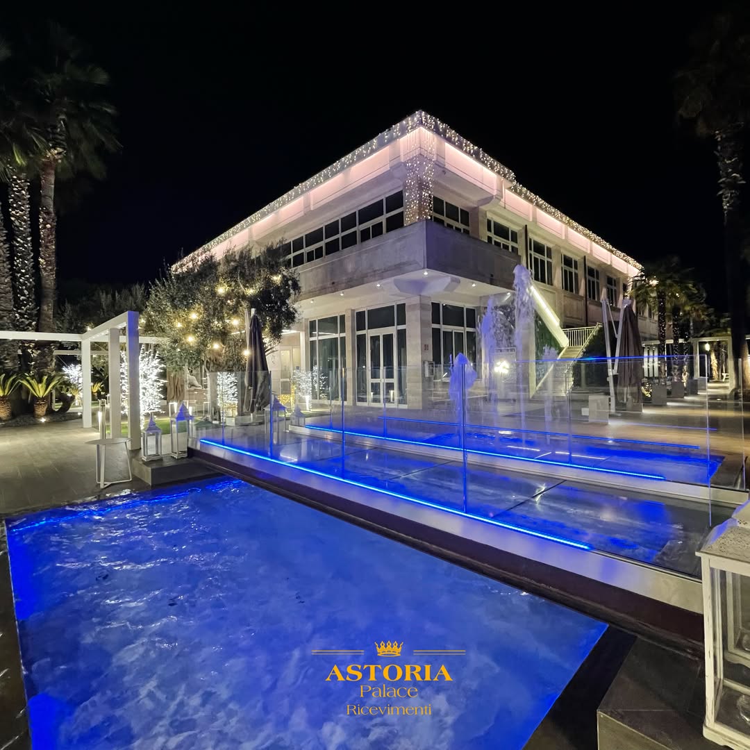 Vista serale della piscina illuminata e dell’Astoria Palace Ricevimenti